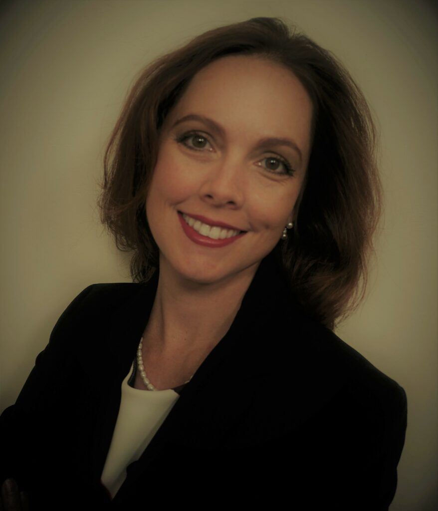 A woman in black jacket smiling for the camera.