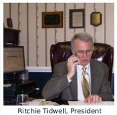 A man sitting at his desk talking on the phone.