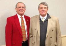 Two men in suits and ties standing next to each other.